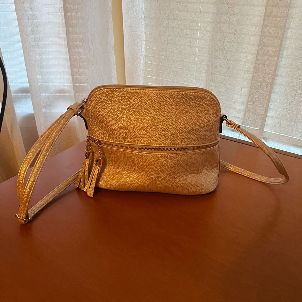 Lt Gold/tan color bag with adjustable strap and gold feet See zippered pockets